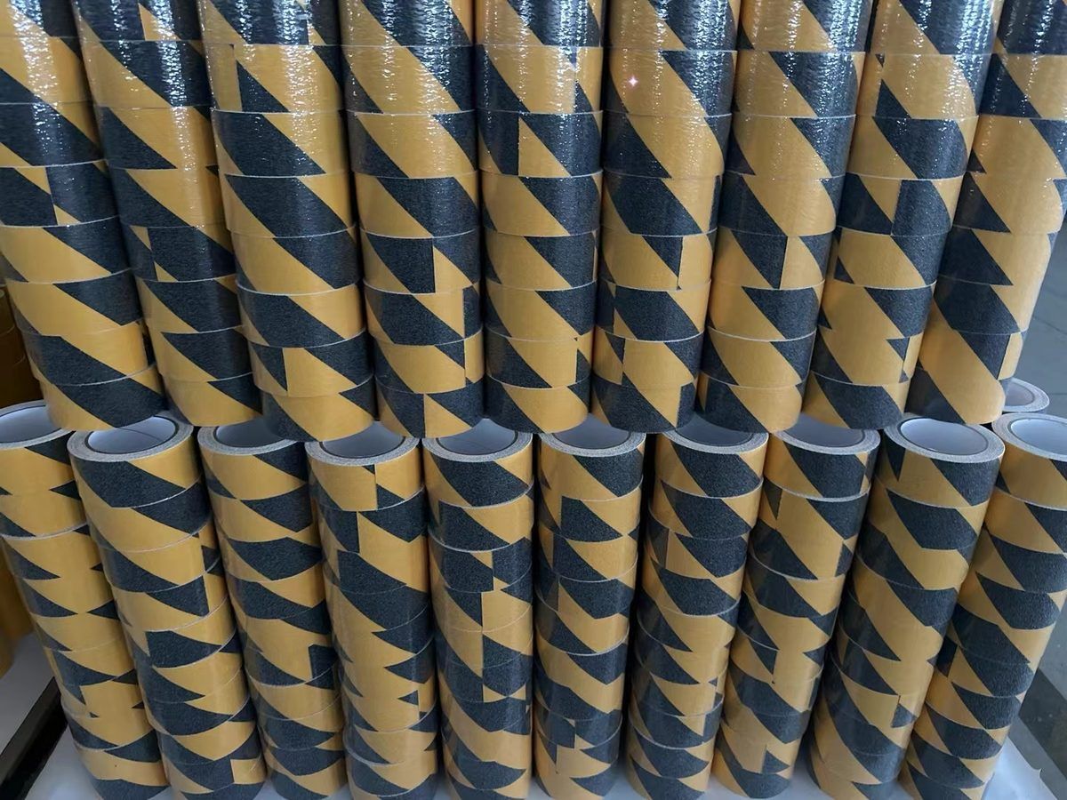 Close-up of stacked black-yellow warning anti-slip tape rolls